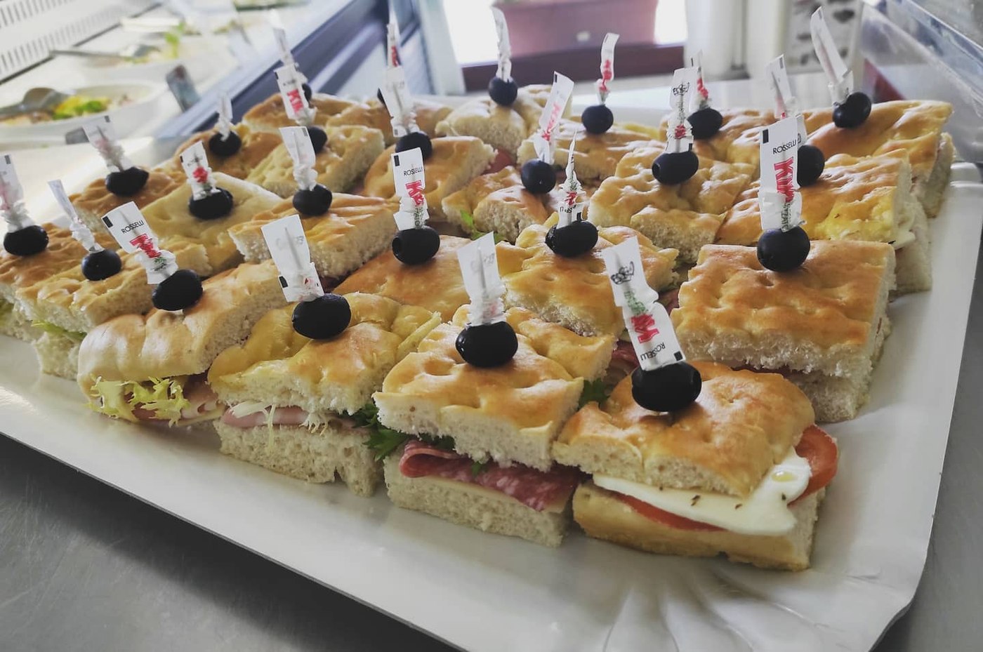 Vassoio di focaccine con salame, prosciutto e mozzarella, olive nere su stecchini, catering Ristopizza da Tony